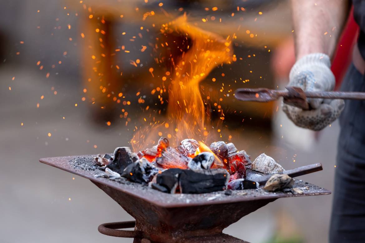 closeup-of-blacksmith-hand-holding-tongs-with-metal-piece-and-heating-it-in-fire-before-forging_t20_eVraX2.jpg